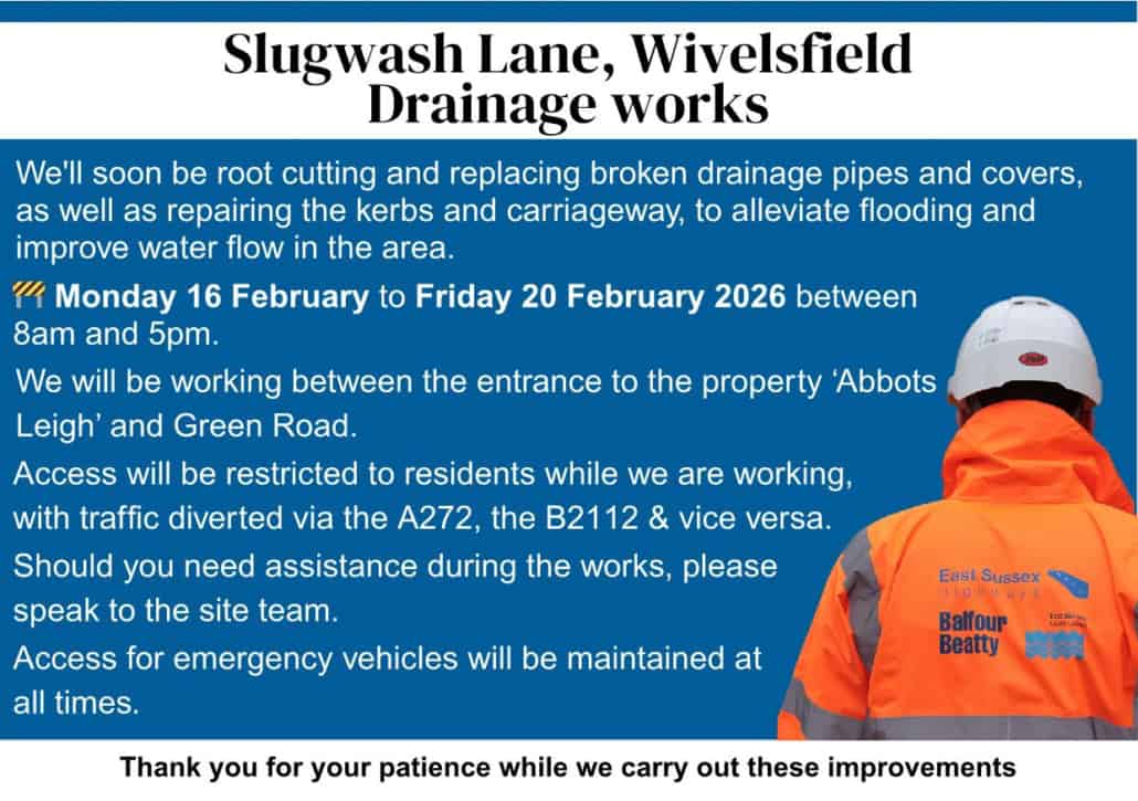 A worker in a hi-vis jacket faces a drainage works notice about road closures in Wivelsfield, East Sussex.